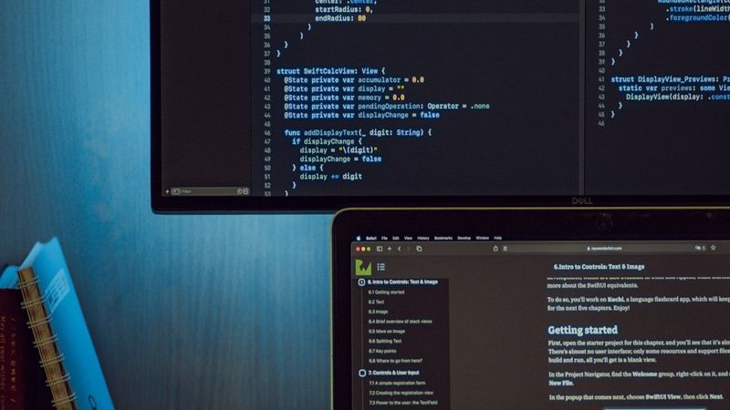 モニターに表示されたモバイルアプリのソースコードと開発ドキュメント