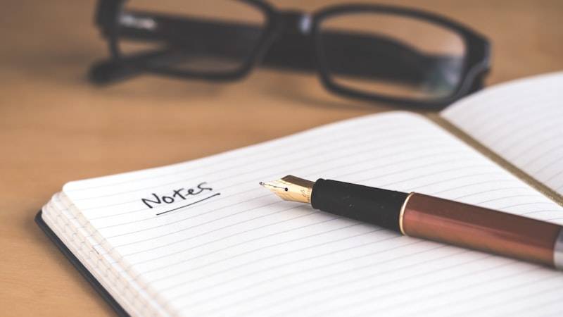 ノートに下書きを書いている手元のクローズアップ
